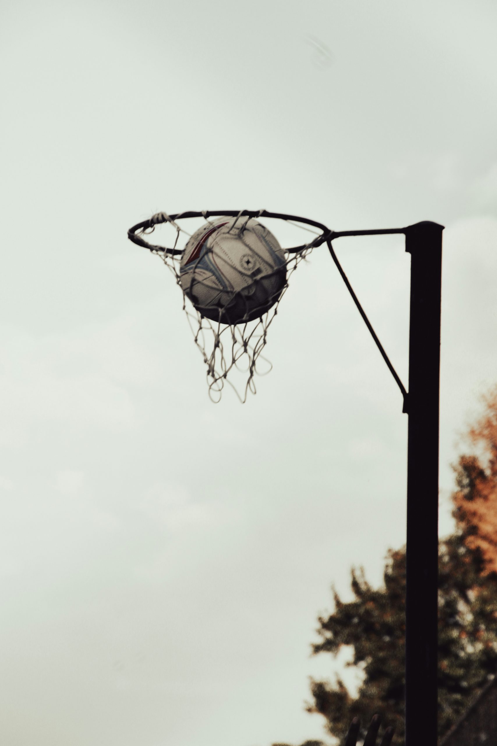 A basketball going through the net of a basketball hoop